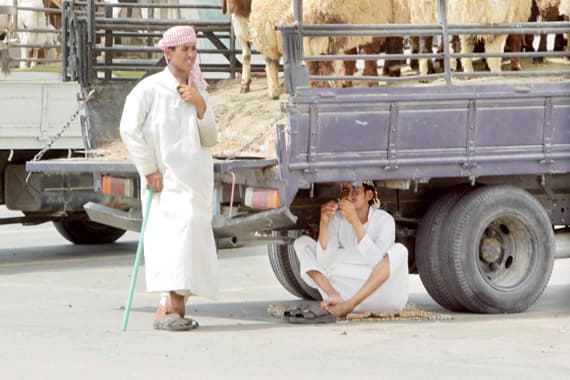 عامل يستنجد بالجلوس تحت سيارة للوقاية من الحرارة المرتفعة.