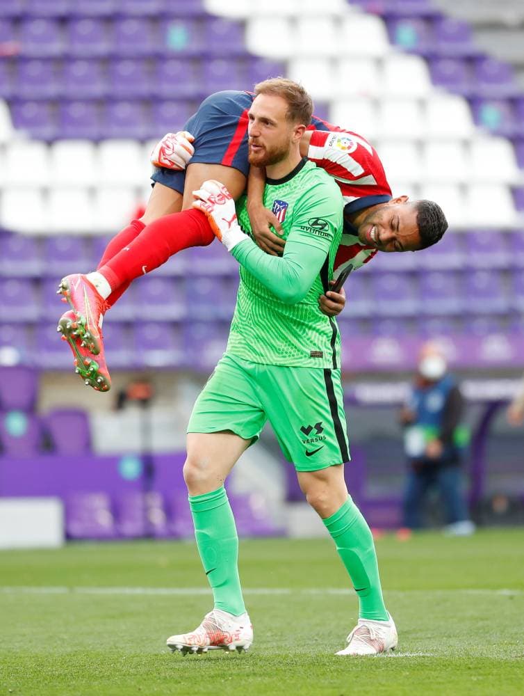 حارس أتليتكو يحمل زميله محتفلين بالتتويج. رويترز