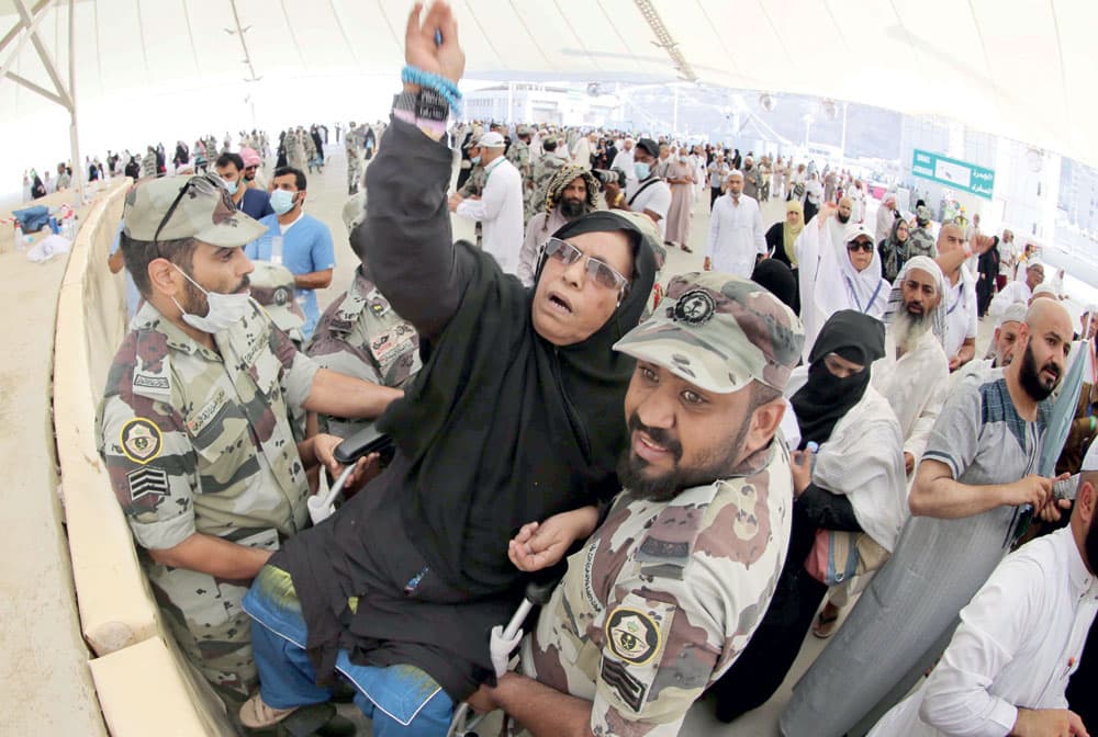 رجلا أمن يحملان حاجة لتتمكن من رمي الجمرات، ما يعكس مدى العناية والاهتمام بالحجيج. 