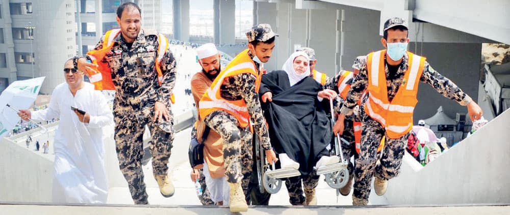 عدد من رجال الأمن يساعدون حاجة للوصول إلى رمي الجمرات.																			             »واس»