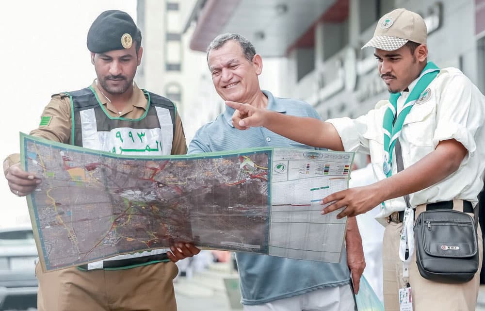 رجل أمن يحاول إرشاد الحجاج التائهين في المشاعر.