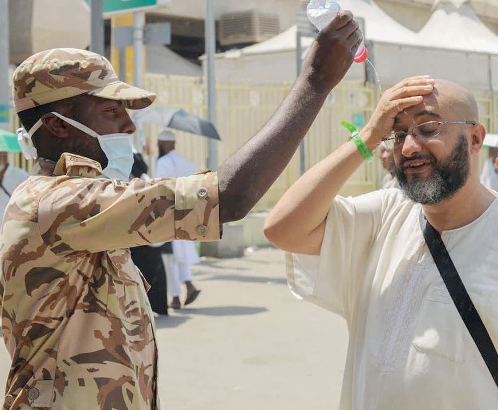 ..وهنا يحاول جندي  تخفيف درجة الحرارة على حاج.