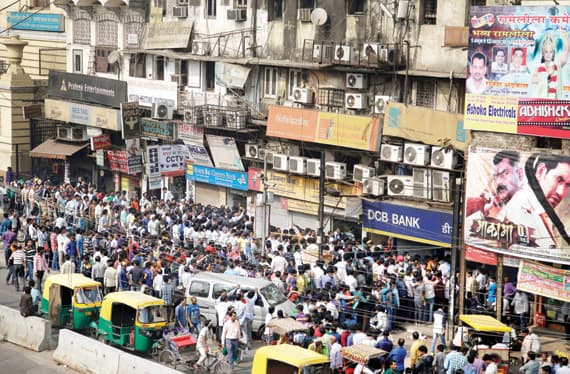 مئات الهنود يحتشدون أمام مصرف في نيودلهي لإيداع واستبدال ما بحوزتهم من الأوراق النقدية فئة خمسمائة وألف روبية التي تقرر بشكل مفاجئ إخراجها من التداول. «أ. ب»