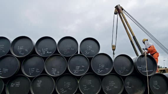 عامل يصف عددا من براميل النفط في وقت تتوقع فيه الأسواق استعادة توازنها هذا العام.