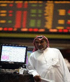كويتي يتأمل في حركة السوق في البورصة الكويتية بعد أن  استأنفت اليوم ( الفرنسية)