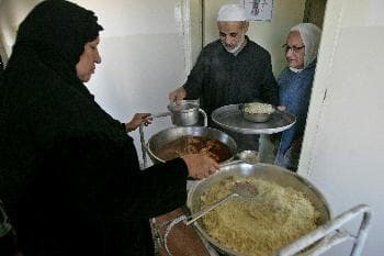 زوجان مسنان يحصلان على الطعام في احدا الملاجئ في بغداد حيث تقدم الخدمات لكبار السن (د ب أ)