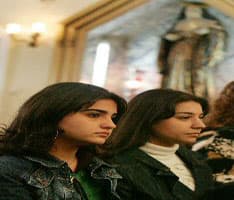 فتاتان عراقيتان أثناء حضور عيد الميلاد في حي االكرادة في بغداد وسط المخاوف الأمنية. (الفرنسية)
