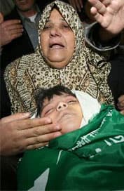 ام فلسطينية مع انبها الشهيد وهو واحد من خمسة في مخيم جباليا شمال قطاع غزة بعد الضربات الجوية الاسرائيلية ( الفرنسية )