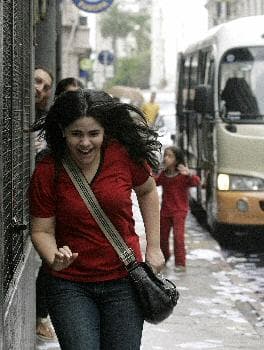 سيدة تجري في آخر ايام عملها و العادة رمي التقاويم وبعض الأشياء على المارة على سبيل المزاح في الاورجواي (د ب أ)