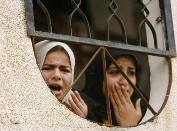 فلسطينيتان تذرفان الدموع من هول المشاهد في غزة (ابراهيم أبومصطفى - رويترز)