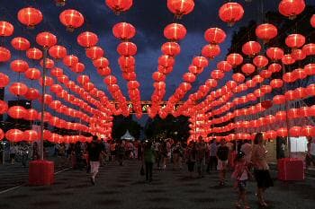 الناس يمشون تحت الفوانيس في هونغ باو مارينا في سنغافورة بمناسبة العام القمري الجديد.