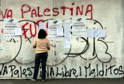 امرأة تتفحص وجود اسمها في قائمة الناخبين خارج مراكز الاقتراع في كراكاس، الفنزولييون توجهوا إلى صناديق الاقتراع في استفتاء على تع