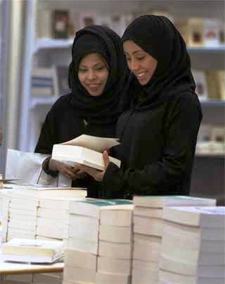 زائرتان لمعرض الكتاب في الرياض تتصفحان احدى الكتب المعروضة في المعرض.