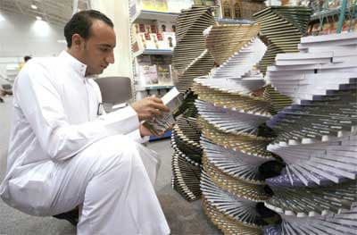 متصفح يقرأ كتاب قد تم عرضه بطريقة جميلة لجذب الزوار في معرض الكتاب المقام حاليا في الرياض.