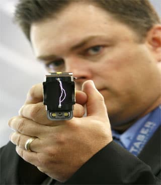 توم سميث رئيس شركة تاسر "Taser" يعرض المنتج الالكتروني "Taser X26" في معرض آسيا العالمي في سنغافورة والذي سيستعمل كأداة للسيطرة 