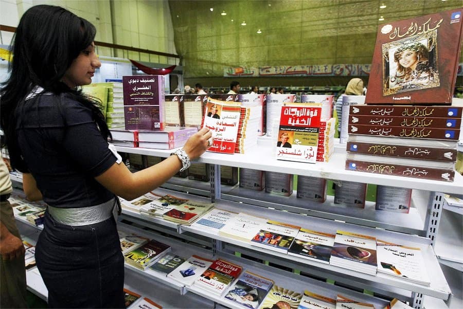 عراقية تتصفح ما هو معروض في قاعة معرض الكتاب الدولي، إحدى فعاليات مهرجان أسبوع المدى الثقافي في بغداد.