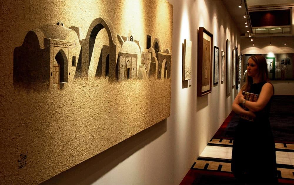 امرأة تشاهد  لوحة من عمل الفنان التشكيلي الإيراني برويز كلانتري في معرض مجموعة دار كريستي في دبي.