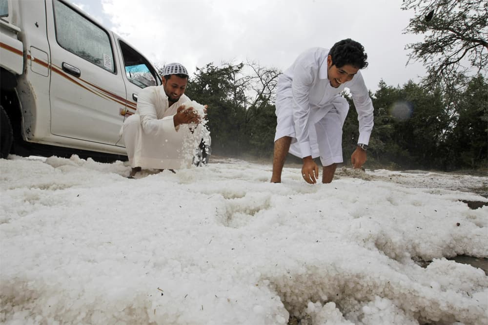شباب يمرحون بالثلج المتساقط في مدينة الباحة.