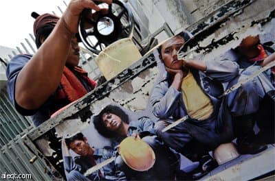 خياط إندونيسي يقوم بعمله على ماكينة الخياطة في شارع رئيسي في جاكرتا.