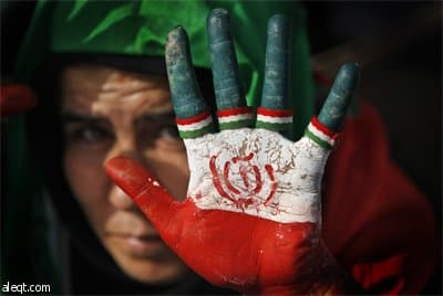 امرأة من أنصار الرئيس الإيراني محمود احمدي نجاد تصبغ ألوان العلم الإيراني على وجهها في مسيرة الحملة الانتخابية على شارع أزادي غر