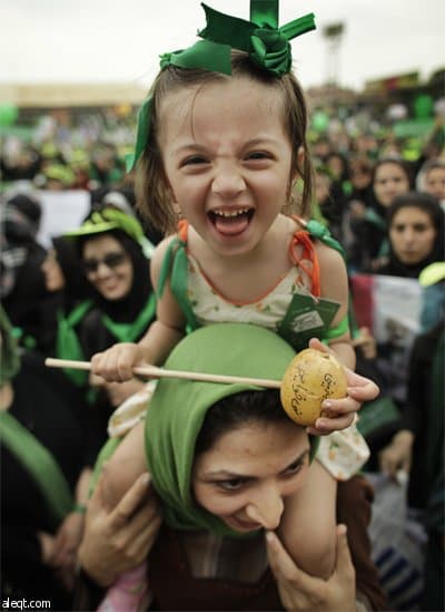 امرأة من أنصار الرئيس الإيراني محمود احمدي نجاد تصبغ ألوان العلم الإيراني على وجهها في مسيرة الحملة الانتخابية على شارع أزادي غر