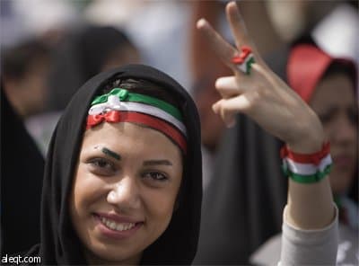 امرأة من أنصار الرئيس الإيراني محمود احمدي نجاد تصبغ ألوان العلم الإيراني على وجهها في مسيرة الحملة الانتخابية على شارع أزادي غر