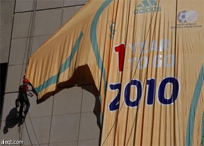 عمال يعلقون قميصا عملاق لكرة القدم على استاد كيب تاون يدل على تبقي سنة واحدة للاستضافة كأس العالم في جنوب أفريقيا.