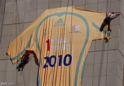 عمال يعلقون قميصا عملاق لكرة القدم على استاد كيب تاون يدل على تبقي سنة واحدة للاستضافة كأس العالم في جنوب أفريقيا.