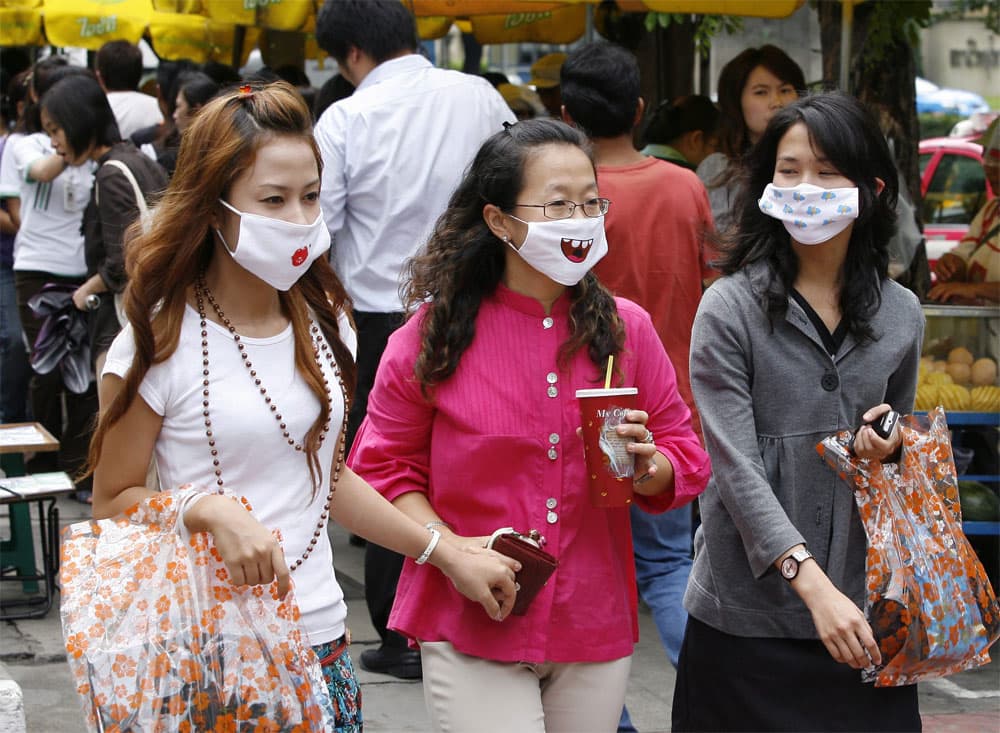 تايلانديات يرتدين أقنعة مرسوم عليها اشكال طريفة بعد إنتشار وباء إنلفونزا الخنازير .