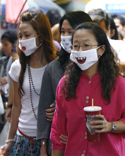 تايلانديات يرتدين أقنعة مرسوم عليها اشكال طريفة بعد إنتشار وباء إنلفونزا الخنازير .