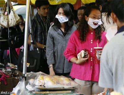 تايلانديات يرتدين أقنعة مرسوم عليها اشكال طريفة بعد إنتشار وباء إنلفونزا الخنازير .