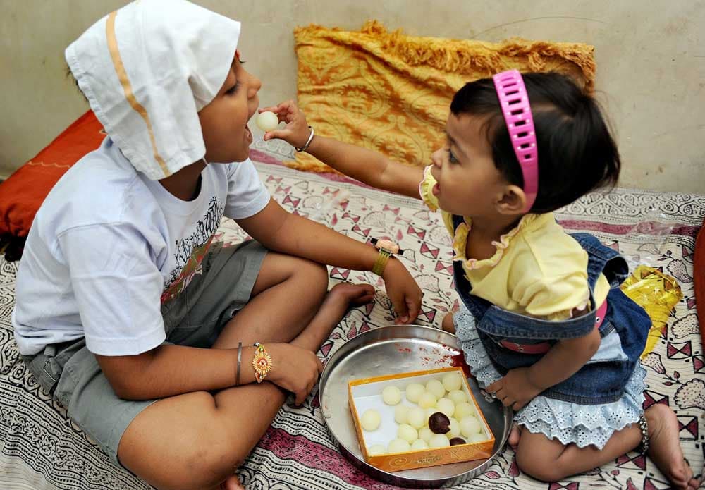 طفلة تطعم الحلوى لشقيقتها في احد مهرجانات نيودلهي  السنوية