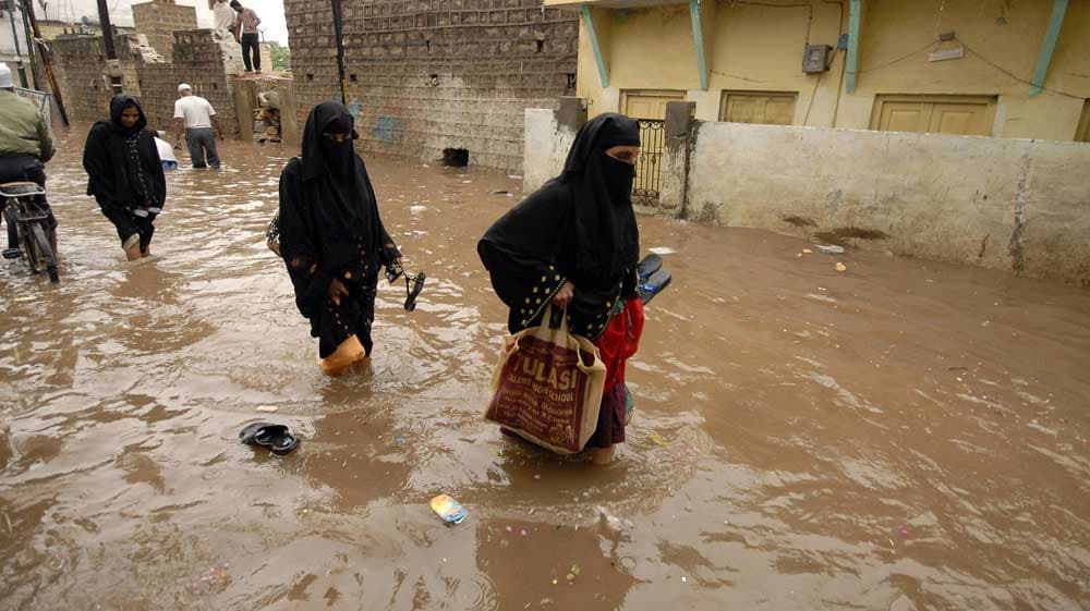هنديات يحاولن شق طريقهن بعد هطول الأمطار الموسمية