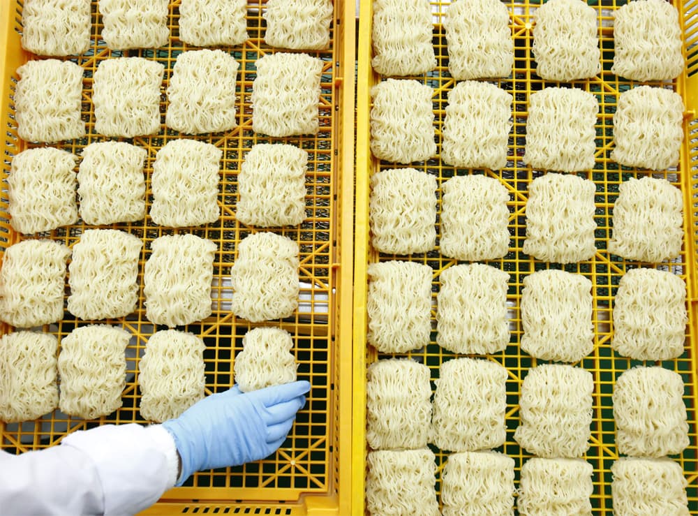 عامل كوري جنوبي يرتب المعجنات الفورية في مصنع للمعكرونة في كانغهوا.