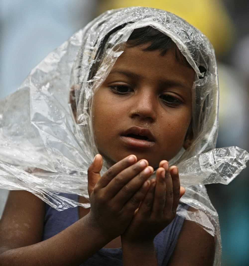 طفل مسلم في المسجد الوطني في دكا يرفع يديه إلى السماء فيما المطر ينهمل منها داعيا الله في آخر جمعة من شهر رمضان المبارك.