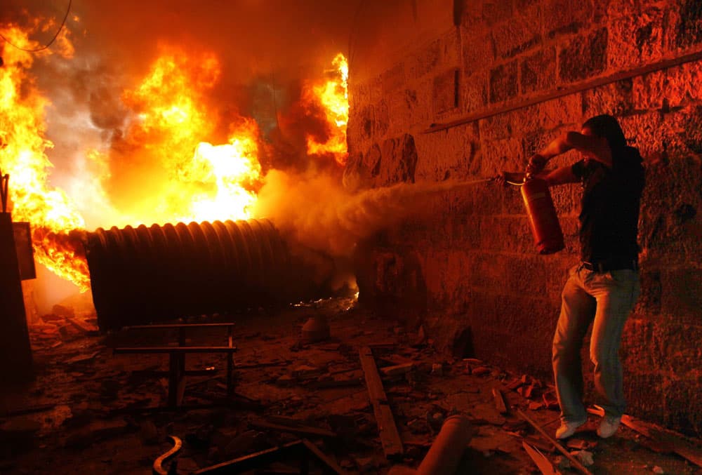 فلسطيني يحاول إخماد حريق بالقرب من أحد أبواب المؤدية إلى المسجد الأقصى حيث يواصل متطرفون يهود تعديهم السافر على أولى القبلتين.