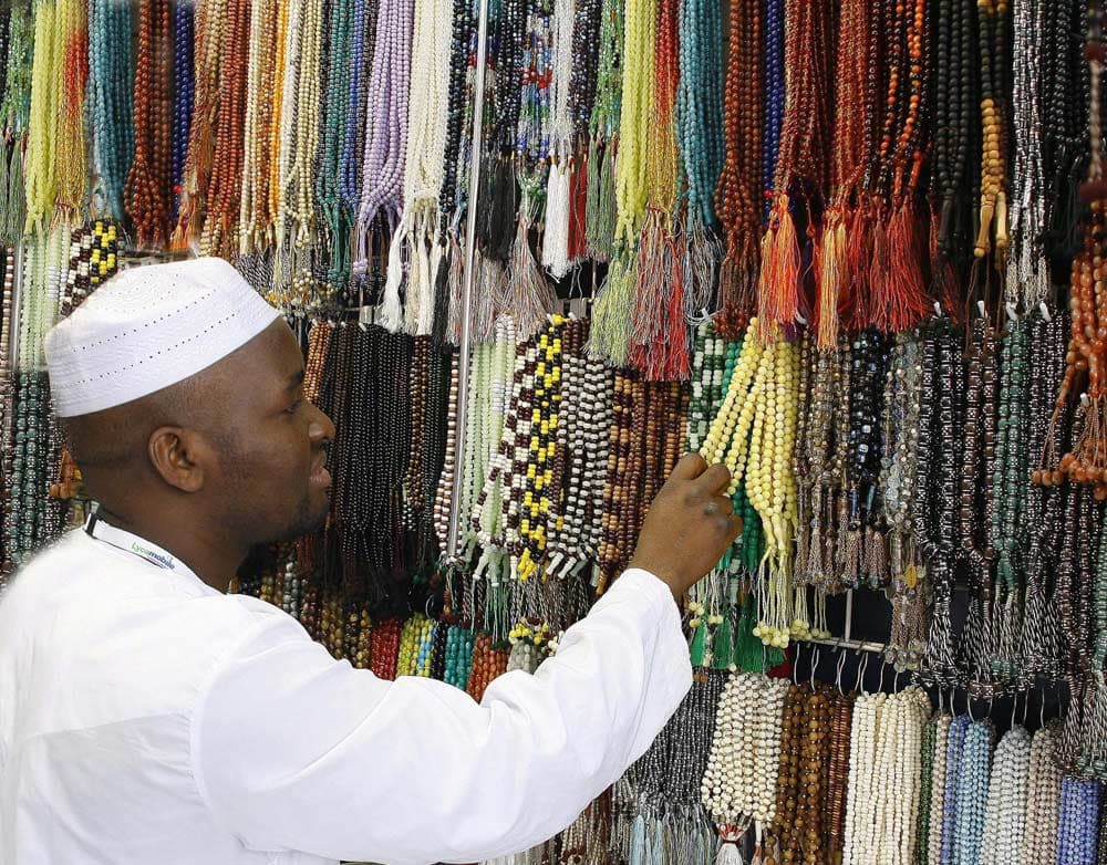 أحد الحجاج يقف أمام متجر لبيع الخرز المكية الشهيرة في مكة المكرمة