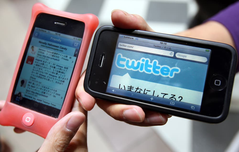 إحدى موظفات شركة "تويتر" اليابانية تظهر صفحة الموقع على الهاتف المحمول microblogging في طوكيو.