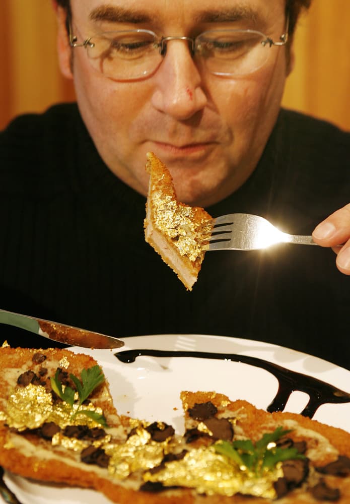 رولاند شوارزر يأكل قطعة من لحم بقري مغطاه بالذهب عيار 24 قيراط ويقدم في وجبة سعرها 190 يورو في أحد مطاعم دوسلدورف.