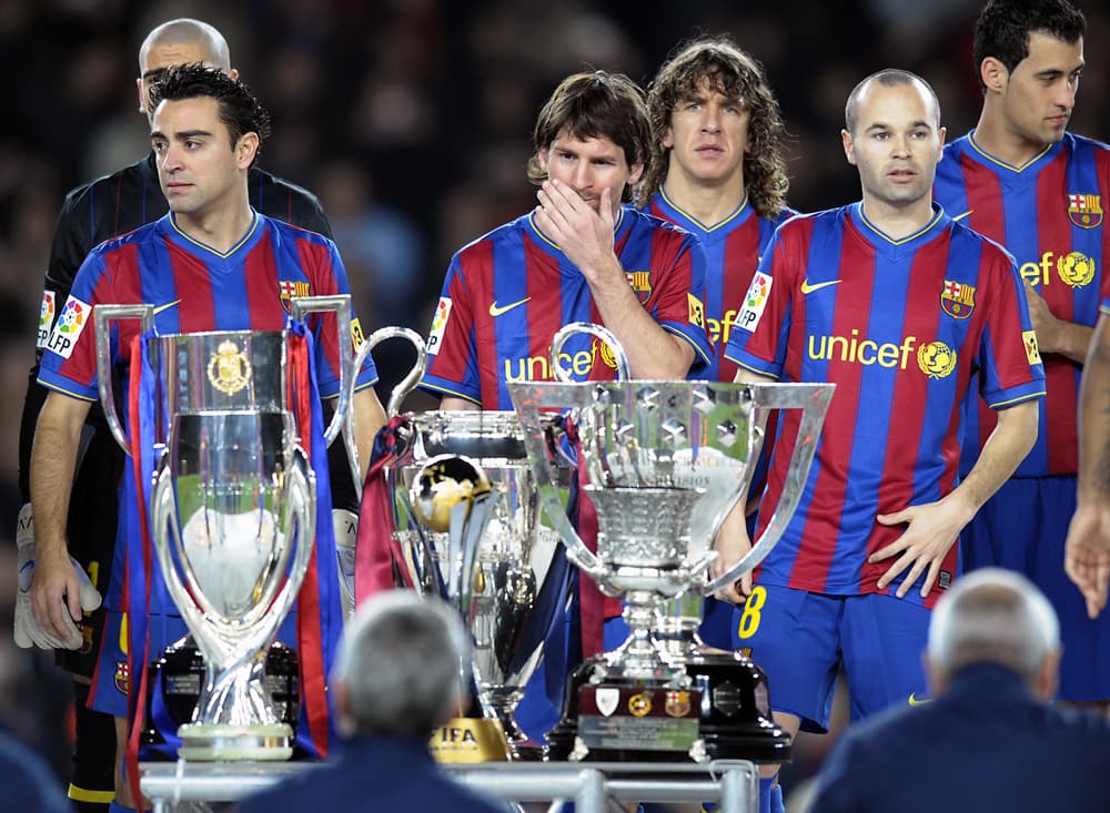 لاعبو نادي برشلونة الاسباني في لقطة جماعية  مع الكؤوس الست والتي تم حصدها خلال موسم 2009/2010  في كرة القدم.