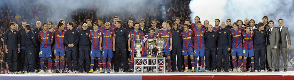 لاعبو نادي برشلونة الاسباني في لقطة جماعية  مع الكؤوس الست والتي تم حصدها خلال موسم 2009/2010  في كرة القدم.