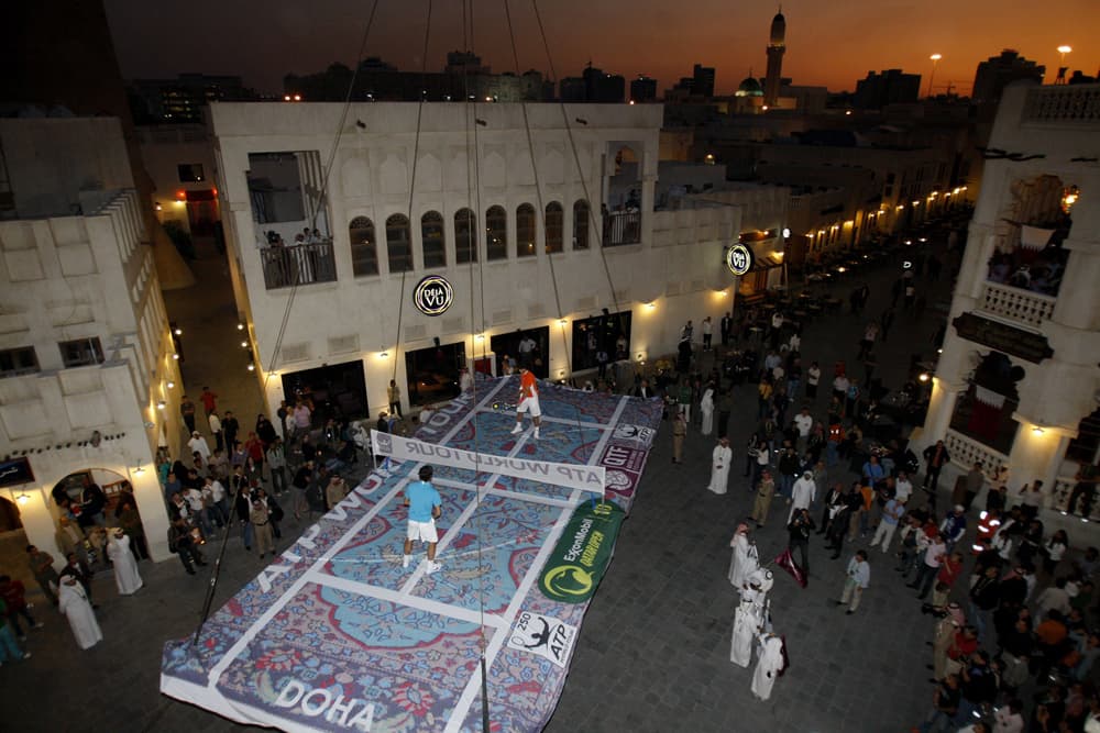 لاعبا التنس العالميان السويسري روجيه فيدرر  والاسباني رافائيل نادال يلعبان على ملعب مصطنع في سوق واقف في العاصمة القطرية الدوحة.