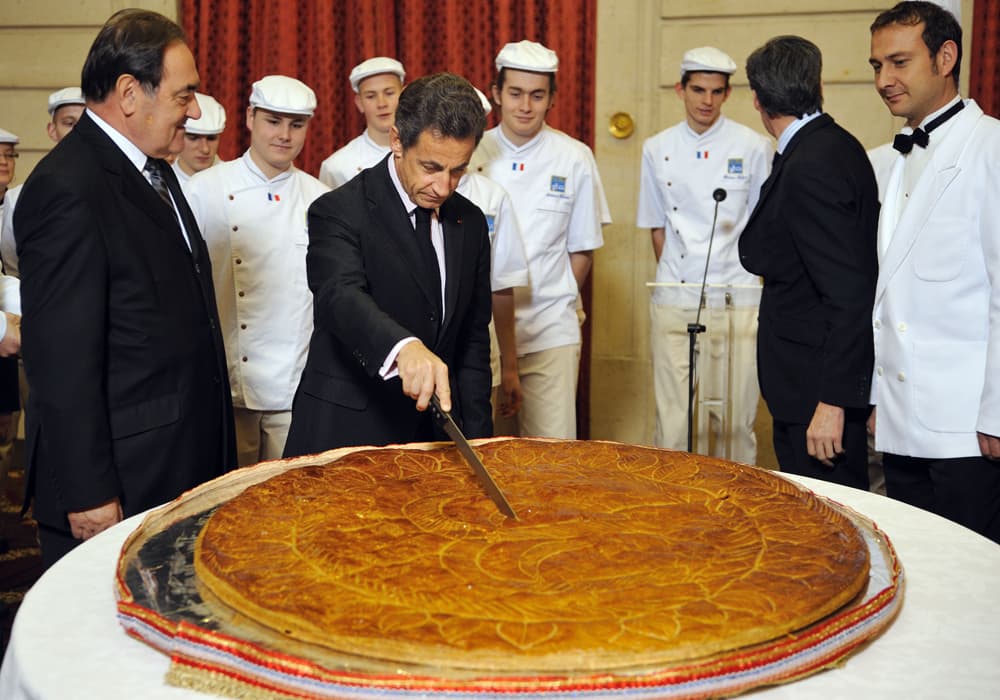 الرئيس الفرنسي نيكولا ساركوزي يقطع كعكة(Galette)  بحضور الرئيس جان بيير في قصر الاليزيه في باريس.