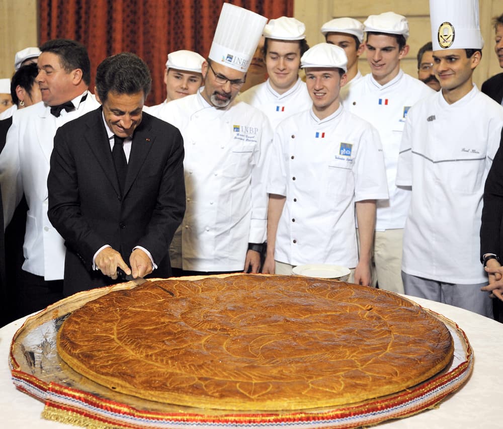 الرئيس الفرنسي نيكولا ساركوزي يقطع كعكة(Galette)  بحضور الرئيس جان بيير في قصر الاليزيه في باريس.