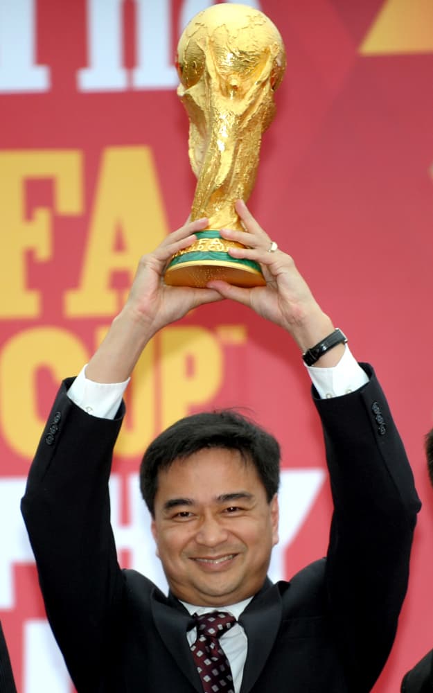 رئيس الوزراء التايلاندي يحمل كأس العالم لكرة القدم خلال حفل ترويجي لبطولة كأس العالم لكرة القدم في بانكوك.