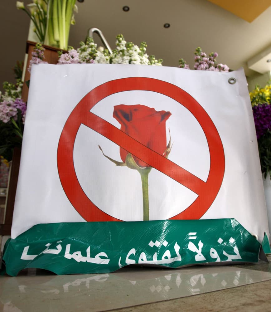 الأردني نائي أوميت يضع لافتة ويغلق محله الخاص لبيع الورود في عمان.