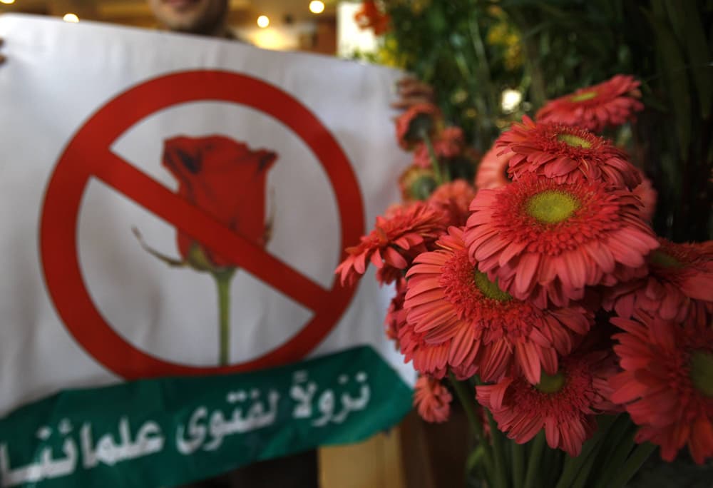 الأردني نائي أوميت يضع لافتة ويغلق محله الخاص لبيع الورود في عمان.