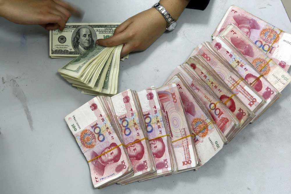موظفة بنك ترتب حزمات من فئة 100 يولن في سوينينغ جنوب غرب الصين.