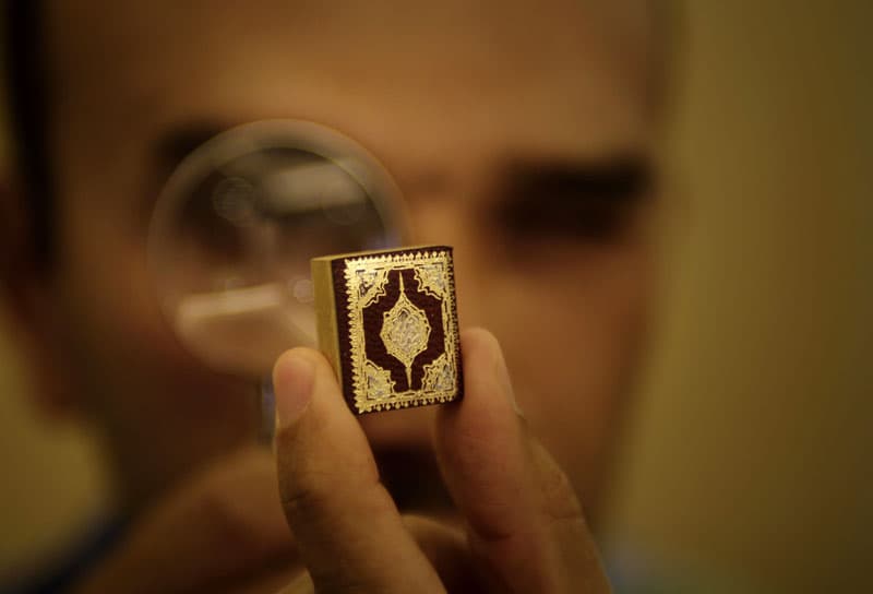 اللبناني حسن عبدربه يعرض أصغر نسخة من القرآن الكريم مكتوبة بخط اليد حيث يبلغ طوله 2.4 سم وعرضه 1.9 سم ويحتوي على 604 صفحة مزينة 