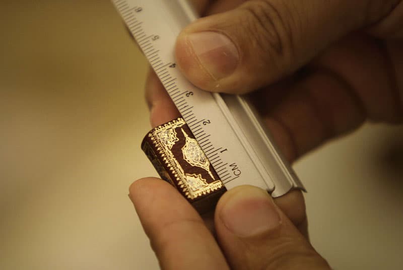 اللبناني حسن عبدربه يعرض أصغر نسخة من القرآن الكريم مكتوبة بخط اليد حيث يبلغ طوله 2.4 سم وعرضه 1.9 سم ويحتوي على 604 صفحة مزينة 